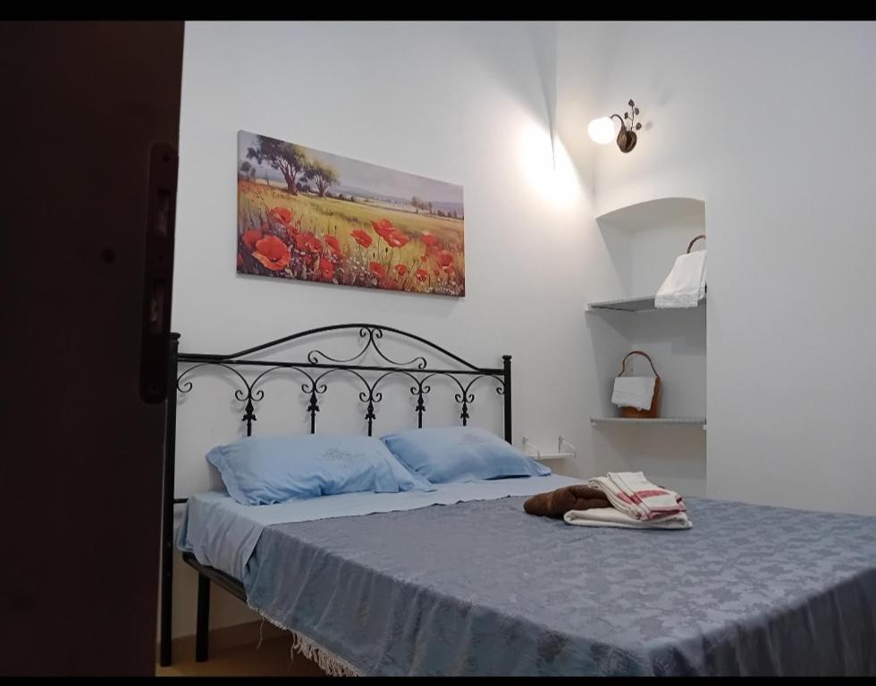 莫尔恰诺迪莱乌卡Margy House的一间卧室配有一张带蓝色枕头的床