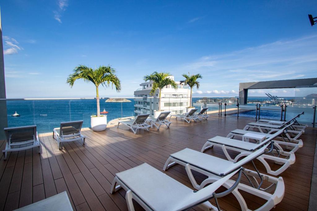 圣玛尔塔Hilton Garden Inn Santa Marta的一个带躺椅的甲板和大海