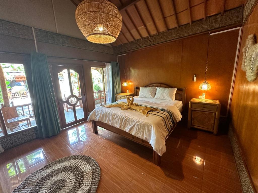 吉利阿尔Sunny Rose Bungalows Gili Air的一间卧室配有一张床和两盏灯及窗户。