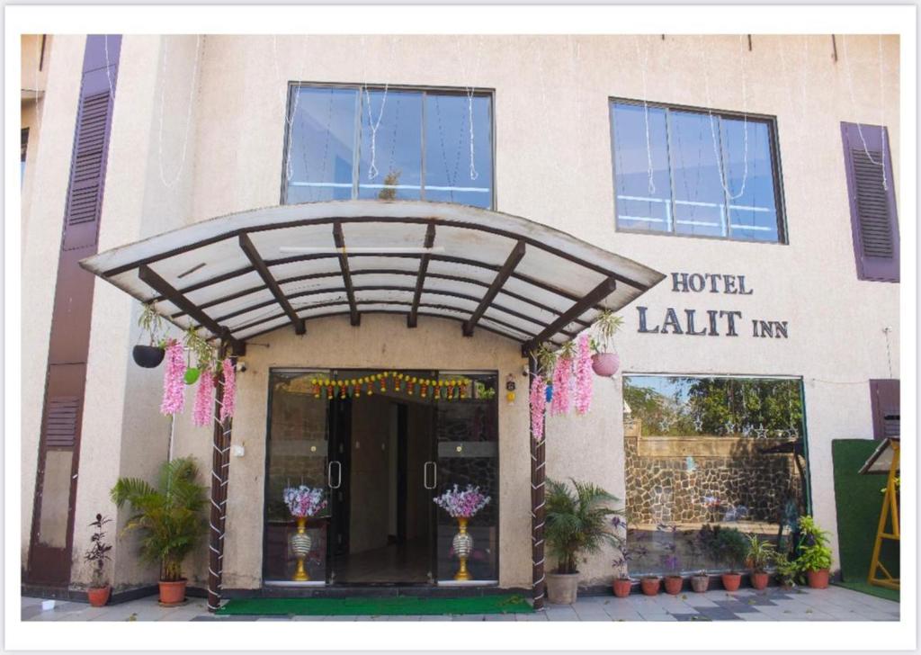 罗纳瓦拉Hotel Lalit inn By Royalstay的建筑前有鲜花的酒店入口