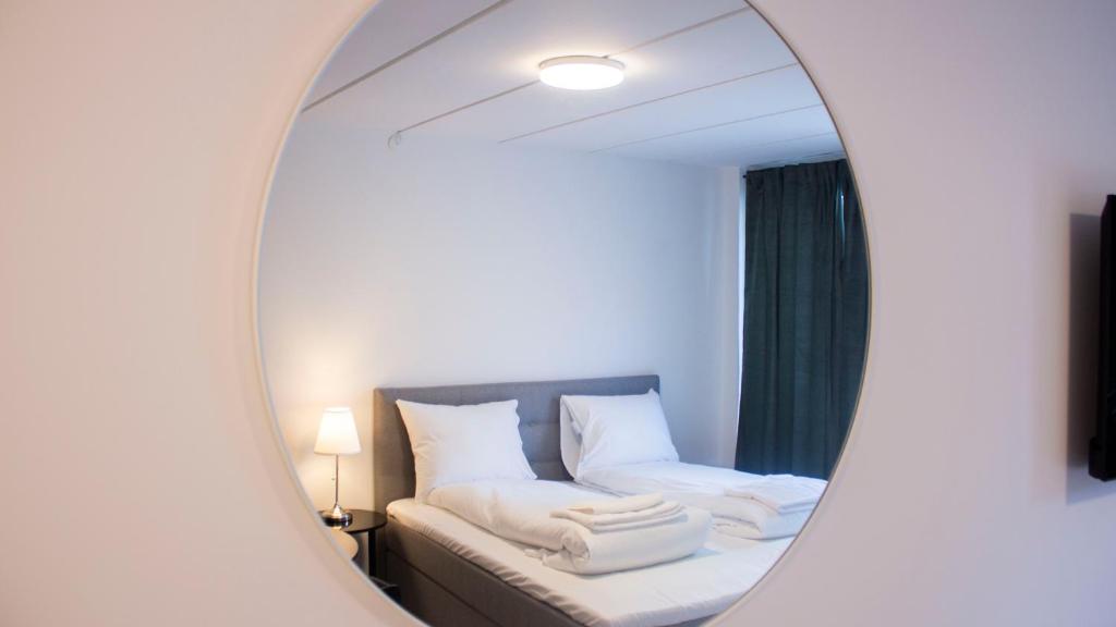 措斯楚斯A Hotels Apartments Høje Taastrup的一张床铺和一张沙发的镜子