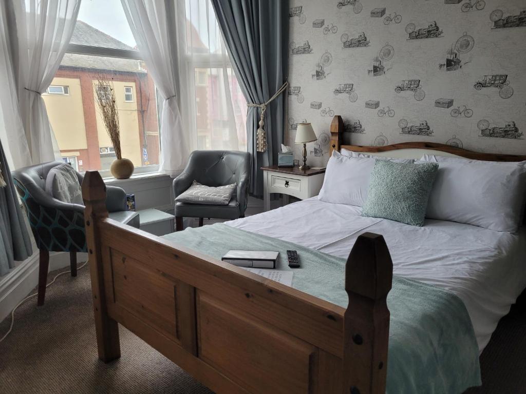 布莱克浦J's Mayfair Guest House的卧室配有床、椅子和窗户。