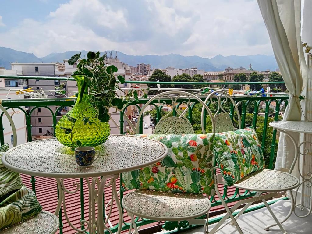 巴勒莫Casa Amari alla Zisa HOSTEL的阳台配有带花瓶的桌椅
