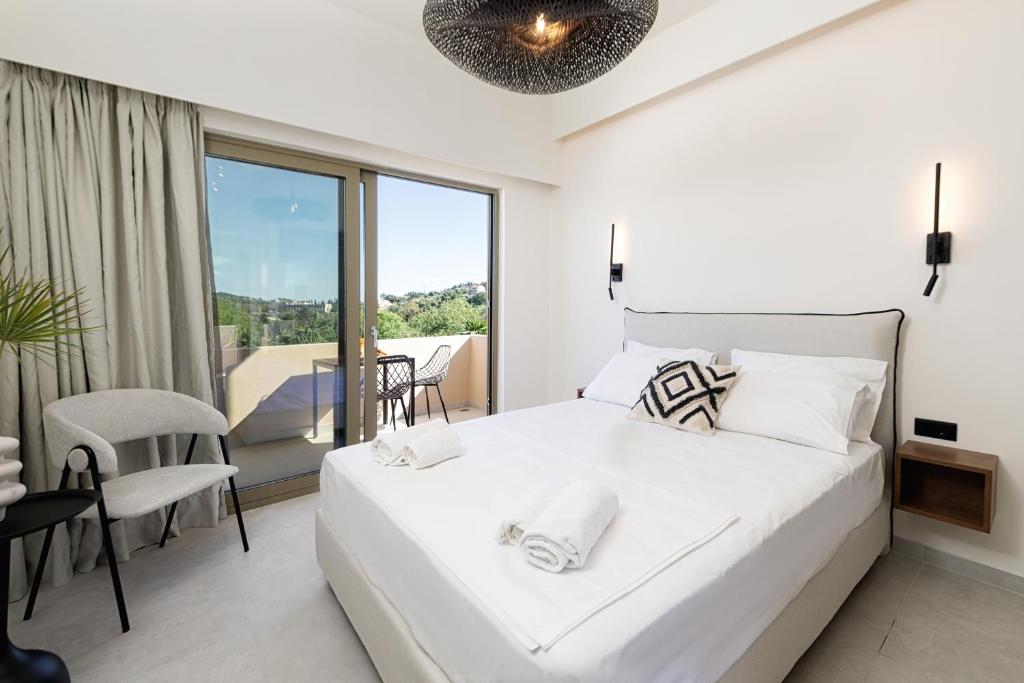 达西亚Little Corfu的白色卧室设有一张大床和一个阳台