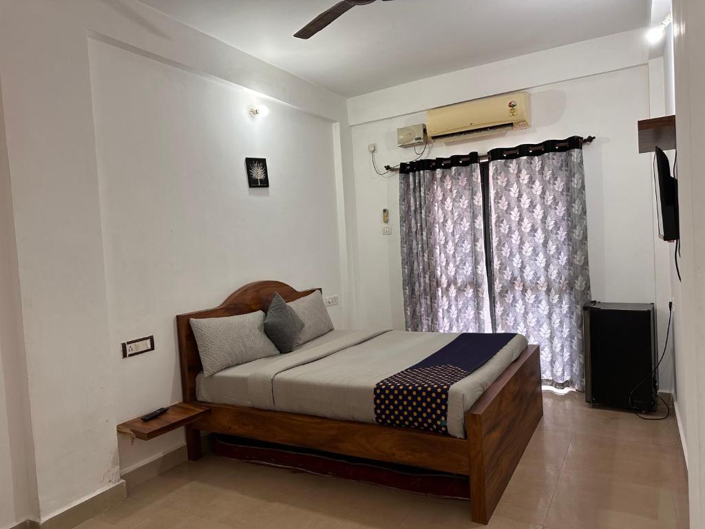 Goasun and sea guest house calangute的一间卧室设有一张床和一个窗口