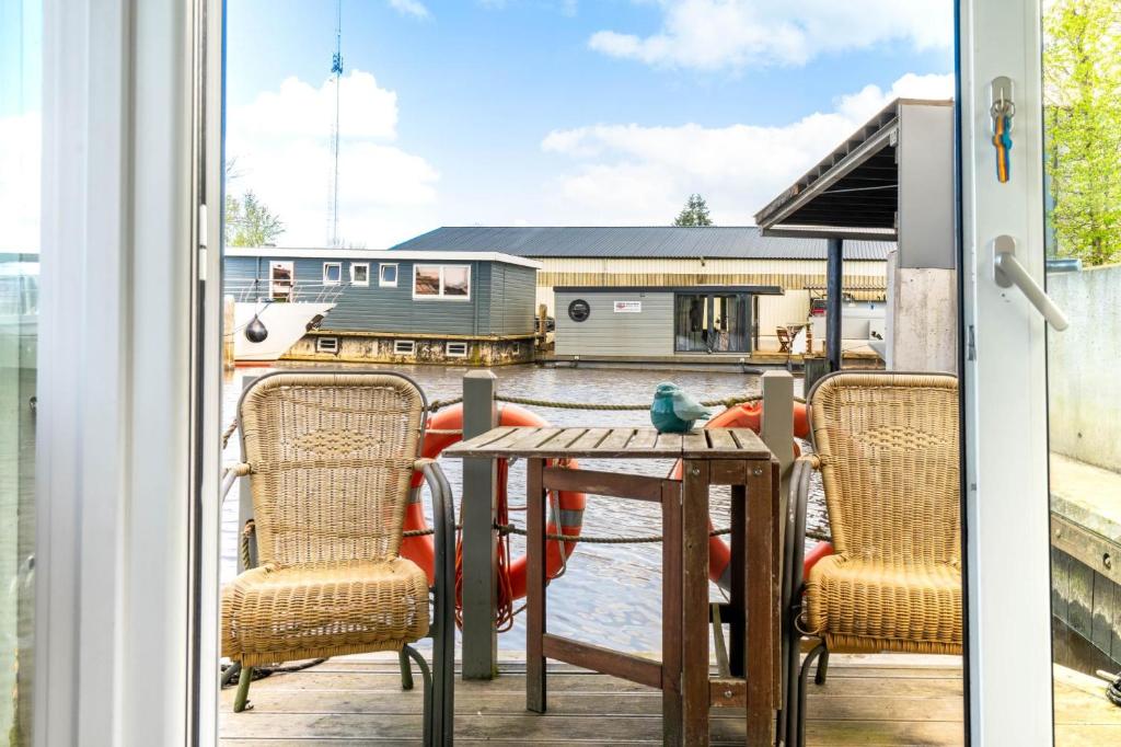 兹瓦茨勒伊斯Charming and cozy Houseboat near Giethoorn的阳台的天井配有桌椅