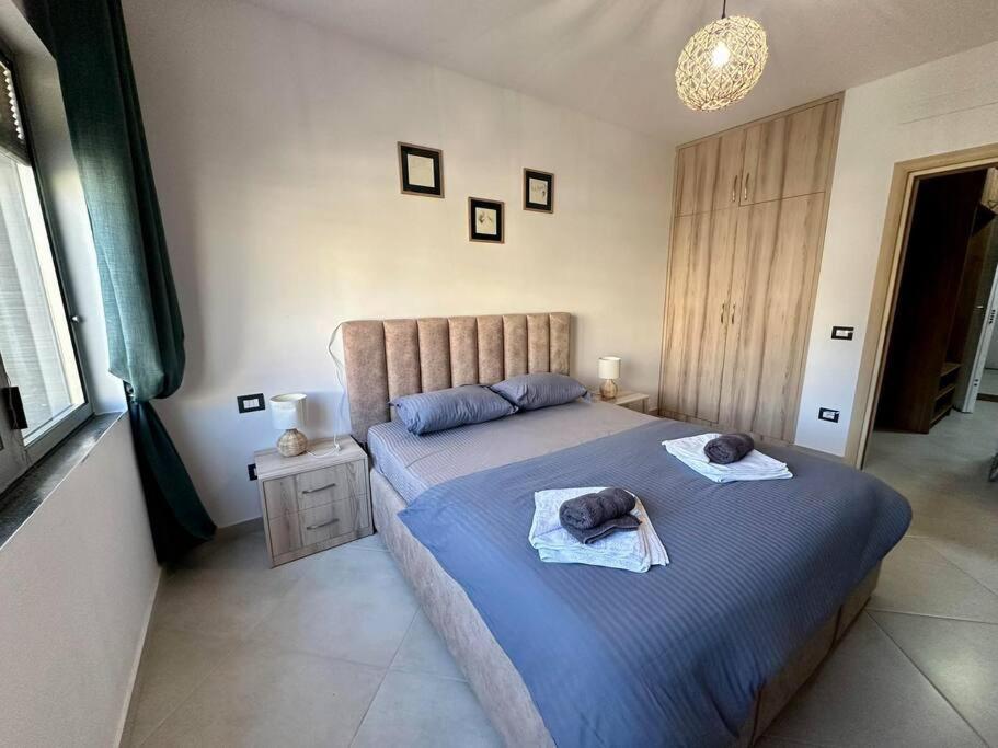 都拉斯Currila Sea View Apartment的一间卧室配有蓝色的床和毛巾