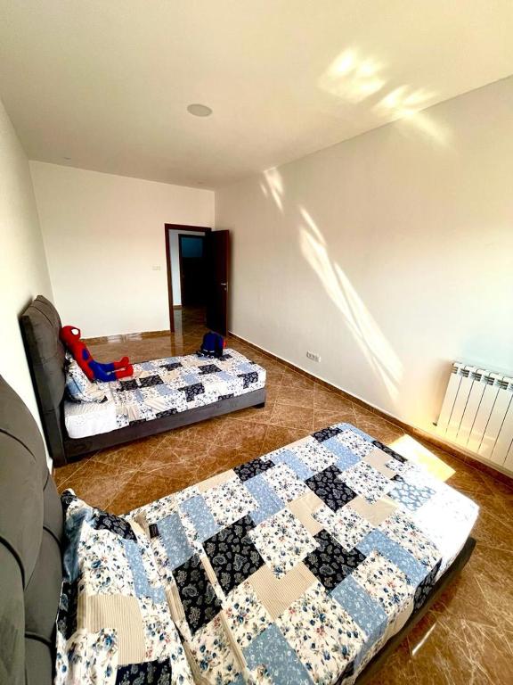 奥兰Residence guessab的宿舍间内的两张床,地板上配有被子