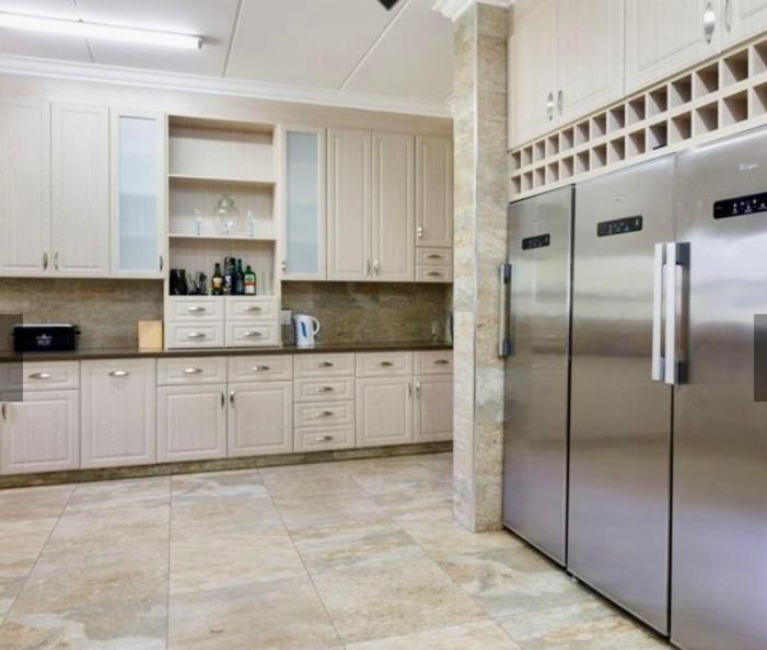 范德拜尔帕克Luxurious House on the water的厨房配有白色橱柜和不锈钢冰箱