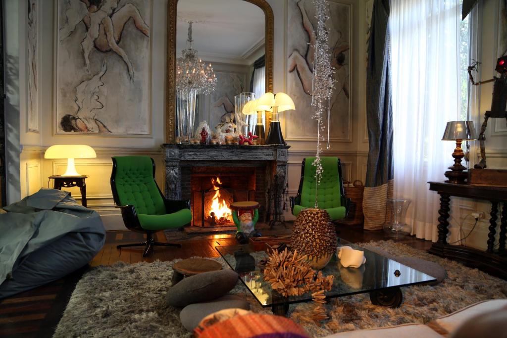 瓦朗西纳大公爵酒店的客厅配有两把绿色椅子和壁炉