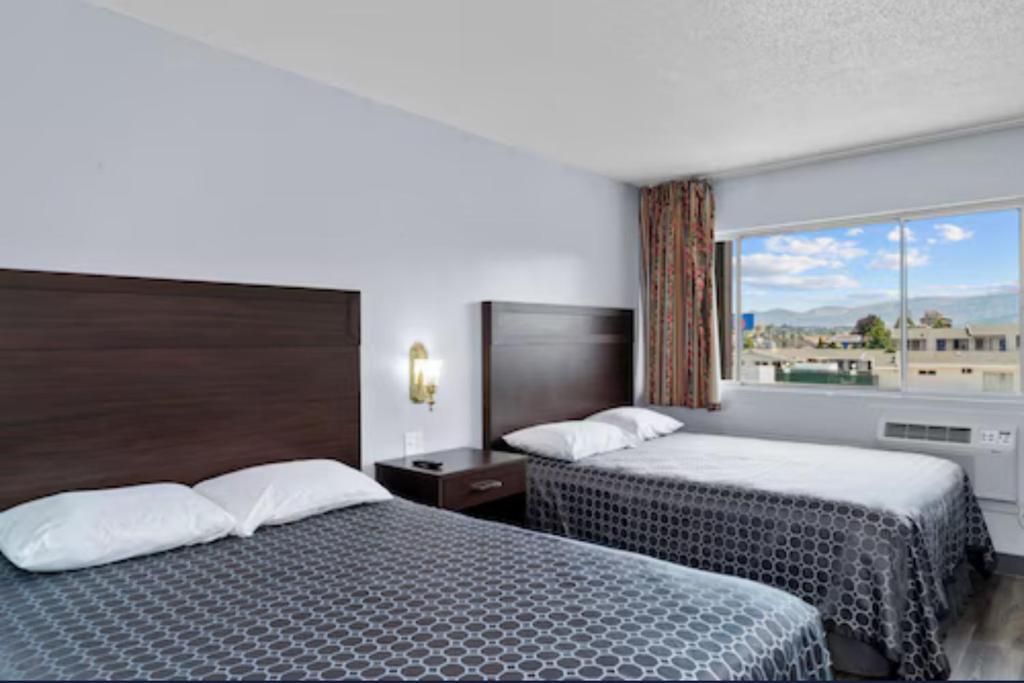 韦纳奇Holiday Lodge的酒店客房设有两张床和窗户。