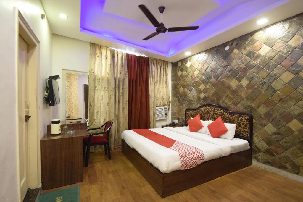 贾姆穆Super OYO Hotel Maa Residency的酒店客房配有一张带吊扇的床。