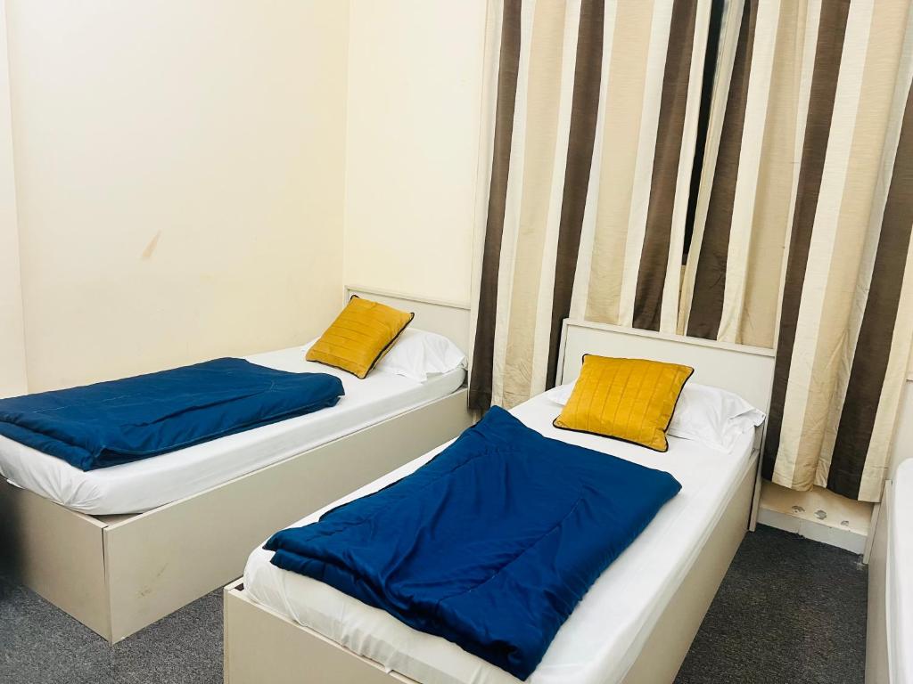 迪拜Short Term Tourist Place的两张带蓝色和黄色枕头的床