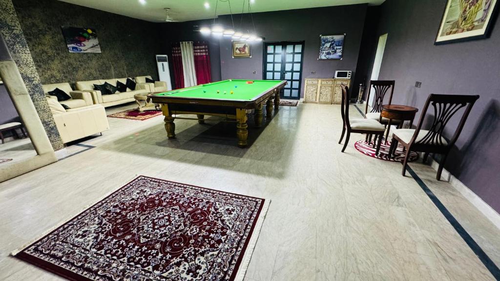 拉合尔Luxury Farmhouse for Stay and Events的客厅配有台球桌和地毯。