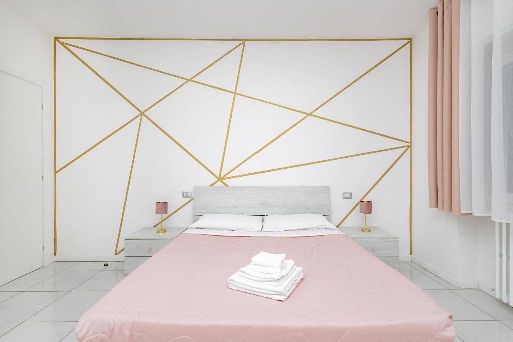 莱科Holidays的一间卧室配有粉红色的床和几何床头板