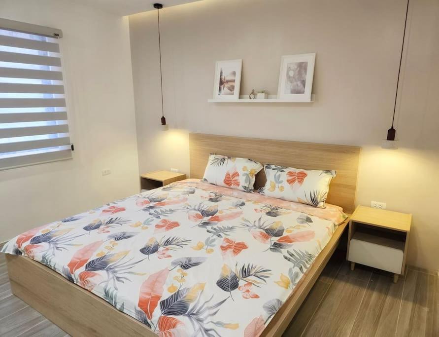 KababaeKiddie Hostel Unit 30B-kids and pets friendly in Subic bay freeport zone的一间卧室配有一张带花卉床罩的床