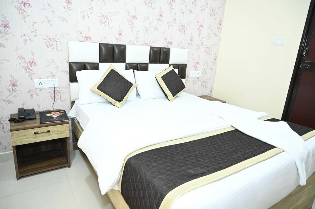 GulzārbāghHotel Glance Inn的一间卧室配有一张大床和一个床头柜