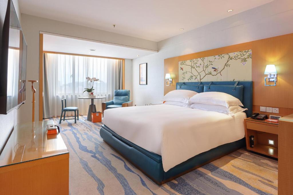 厦门厦门航空金雁酒店（全新室内无边泳池）的酒店客房设有一张大床和一张桌子。