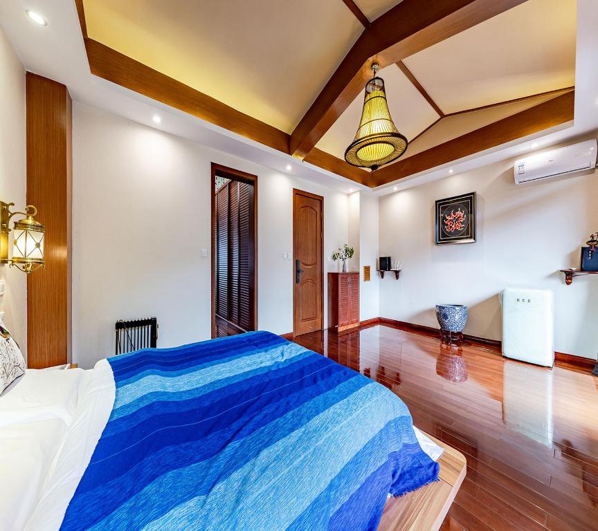 昆明Annie Dianchi Lake Villas的一间卧室配有一张带蓝色毯子的大床