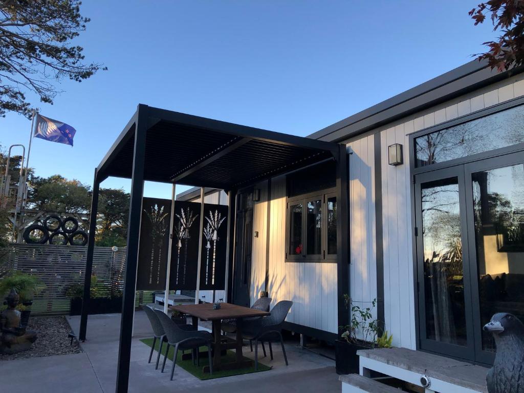 Egmont VillageTiny Home Luxury Farm Escape的庭院内的房子,配有桌椅