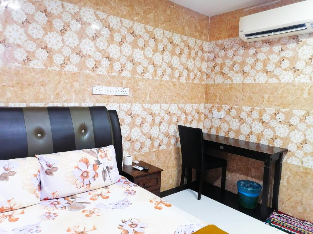 莎阿南ARK HOTEL SUBANG的一间卧室配有一张床和一张桌子及椅子