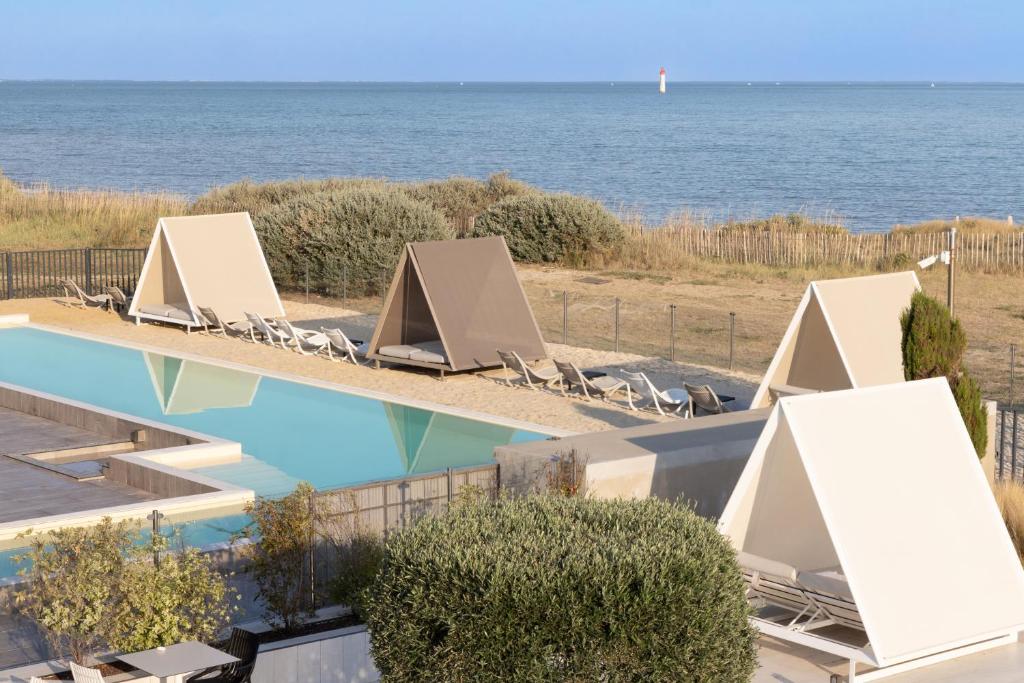 雷岛圣玛丽阿塔兰特瑞莱城堡连锁酒店及Spa - 康体酒店 的一个带椅子的游泳池,背景是大海