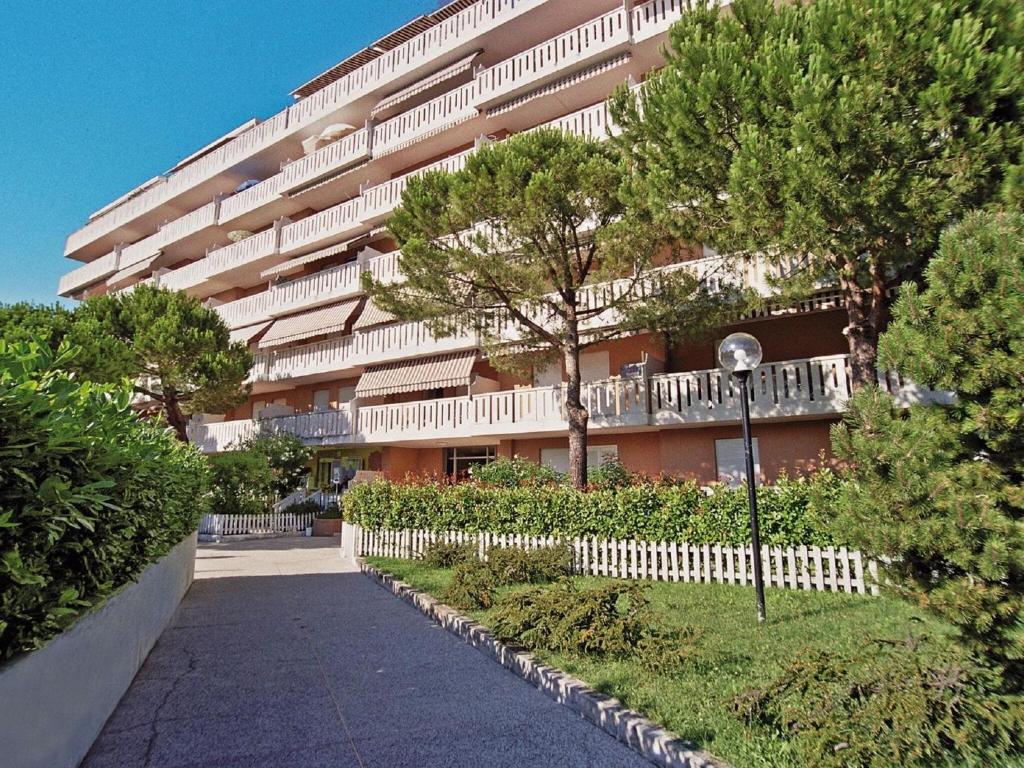 圣玛格丽塔波尔勒港Belvilla by OYO Nicesolo 39的大型公寓大楼设有白色的围栏和树木