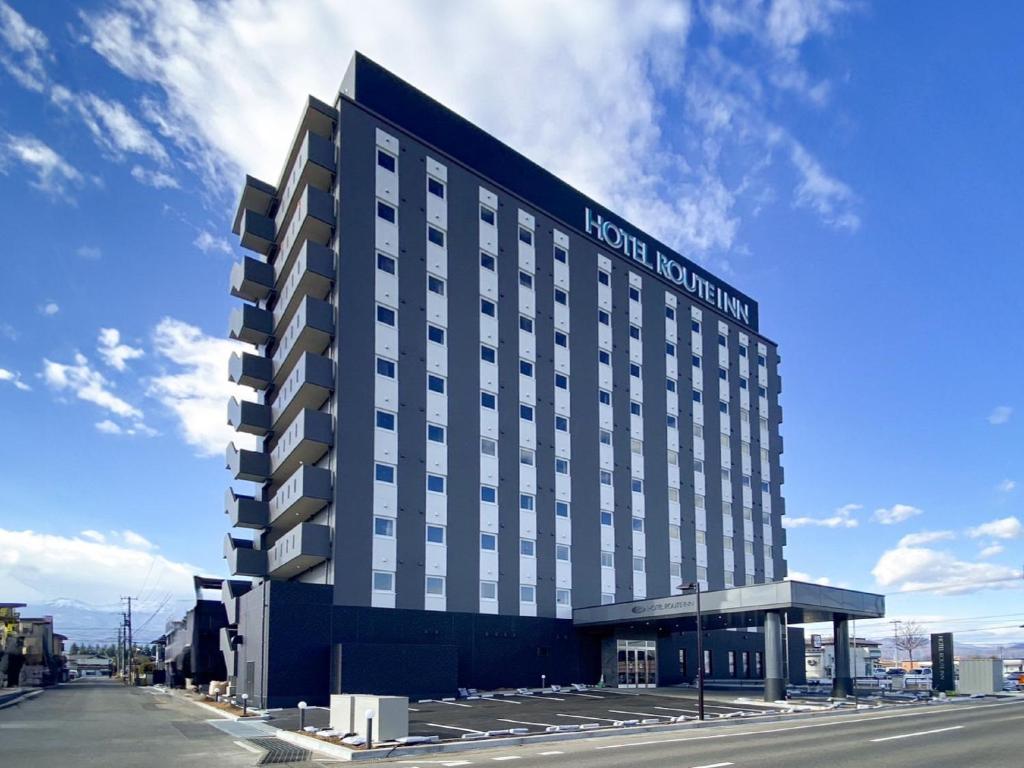 福岛Hotel Route Inn Fukushima Nishi Inter的酒店大楼的一侧有标志