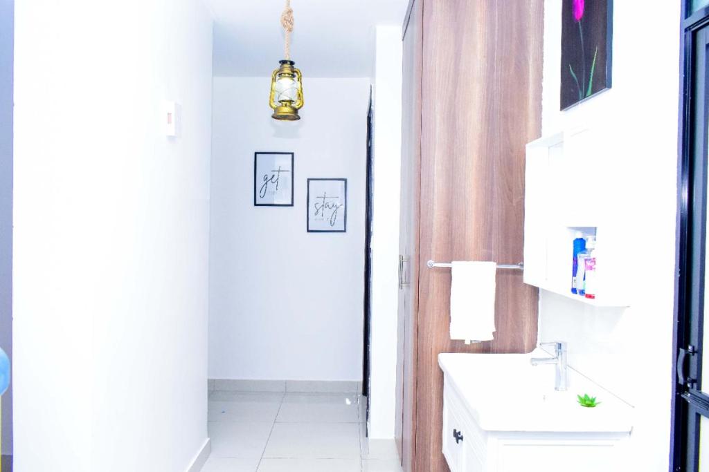 马查科斯Amalia Apartments Syokimau的白色的浴室设有水槽和镜子