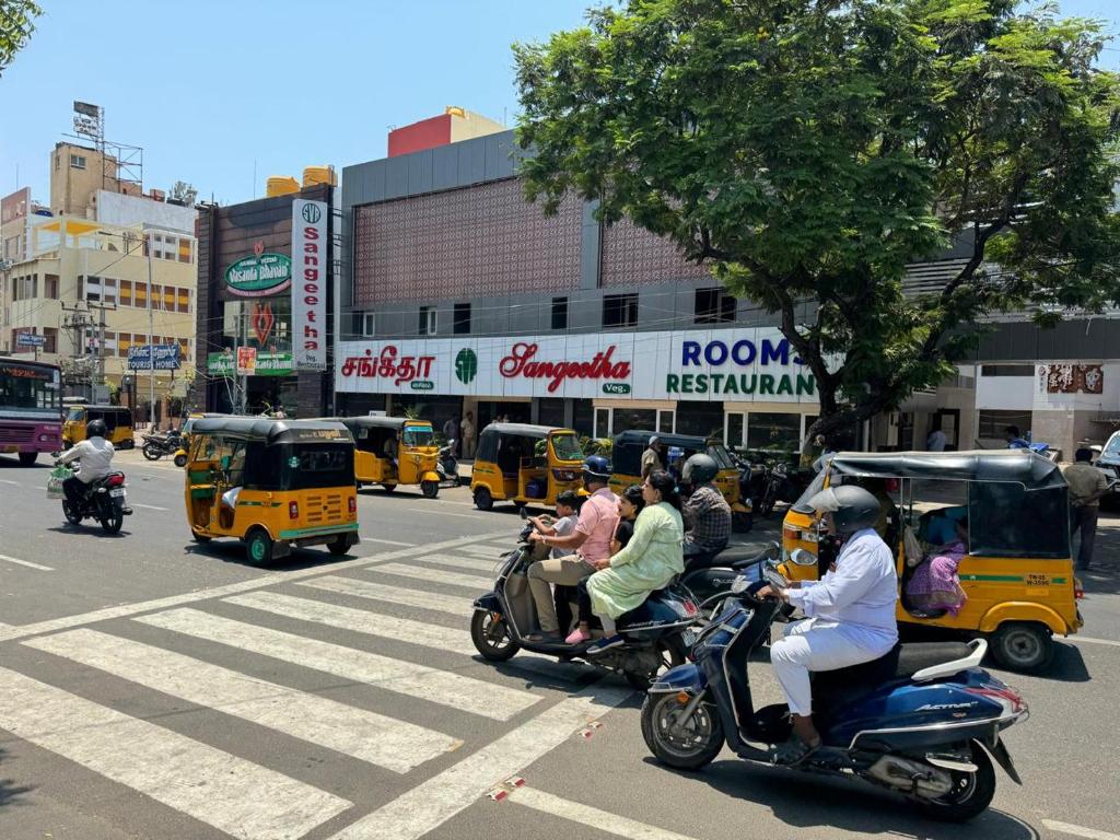 钦奈Sangeetha Business Hotel的一群人在繁忙的城市街道上骑摩托车