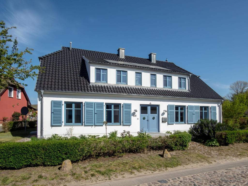 格罗斯齐克Dat Dörphus am Bodden - WG 01的街上有蓝色百叶窗的白色房子