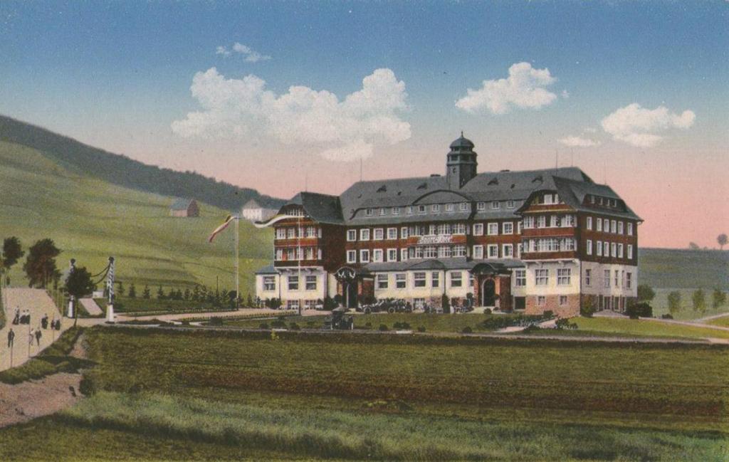 奥泊维森塔尔Summit of Saxony Resort Oberwiesenthal的 ⁇ 染一个田野上大建筑