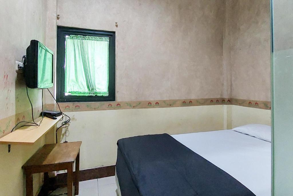 SelapajangNi Hotel Syariah Bandara Soekarno Hatta Mitra RedDoorz的一间小卧室,配有一张床和电视