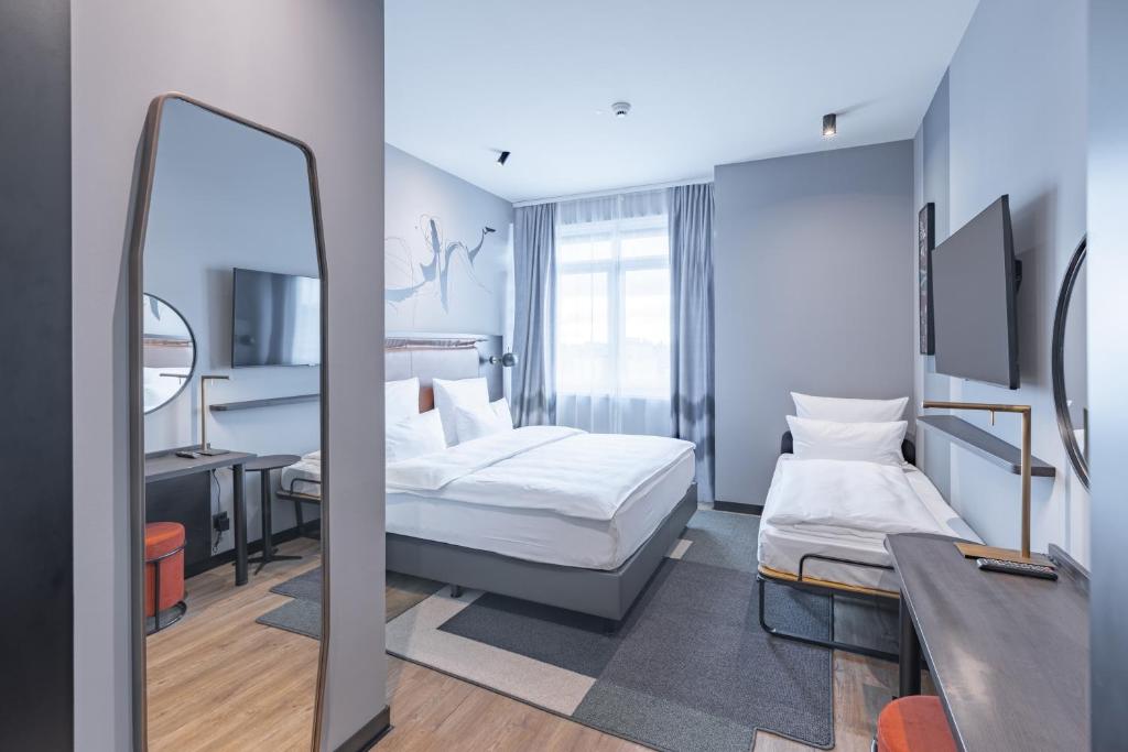 柏林TITANIC Comfort Kurfürstendamm的酒店客房,配有床和镜子