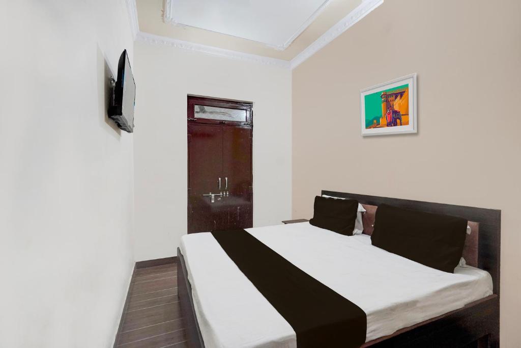 密拉特OYO Hotel Maharaja Palace的一间白色客房内的床铺卧室
