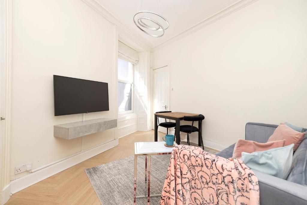 爱丁堡Modern flat in City Centre - For up to 3 guests的客厅配有沙发和墙上的电视