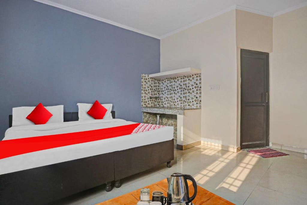 新德里OYO Hotel Dreamland Residency的一间卧室配有一张带红色枕头的床和壁炉