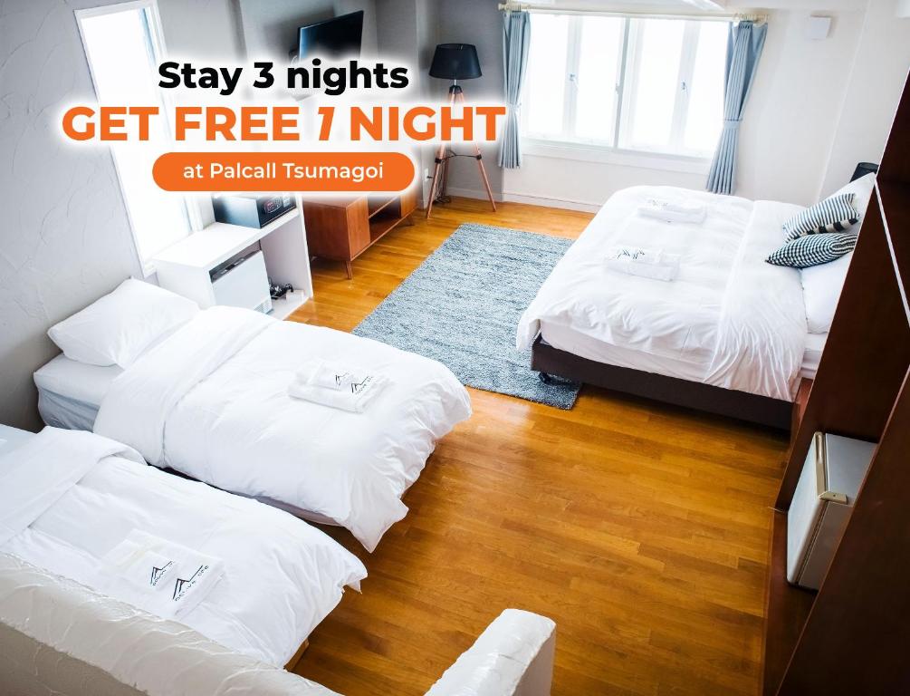 饭山市马达劳积极生活酒店的一间设有两张床的客房和一个标志,显示住宿夜晚可免费入住