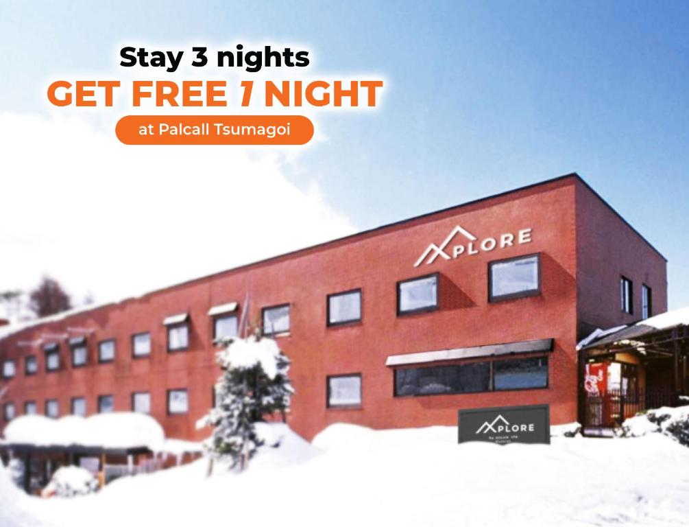 饭山市主动生活的Xplore酒店的一座建筑,上面标有“住宿之夜免费”的标志