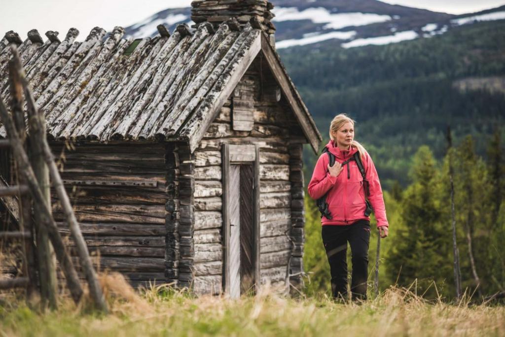 TrillevallenTrillevallens Högfjällshotell & Lägenheter的站在旧建筑前面的女人