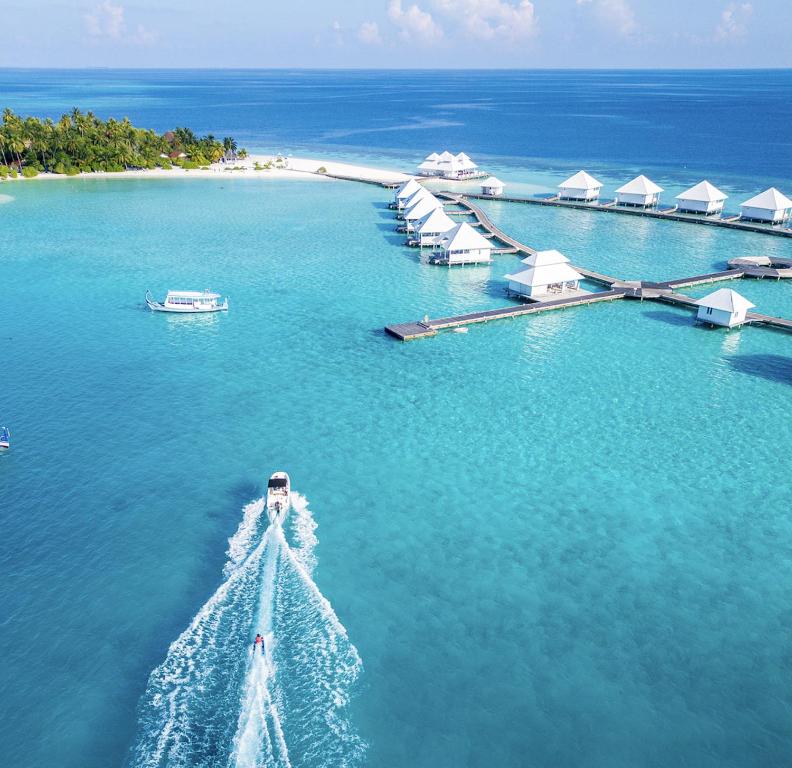 阿沙格岛Diamonds Athuruga Maldives Resort & Spa的海中的一个岛屿,在水中划船