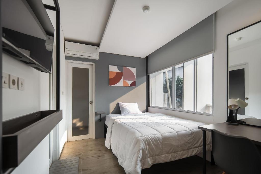 雅加达Cove Art Living的卧室配有白色的床和窗户。