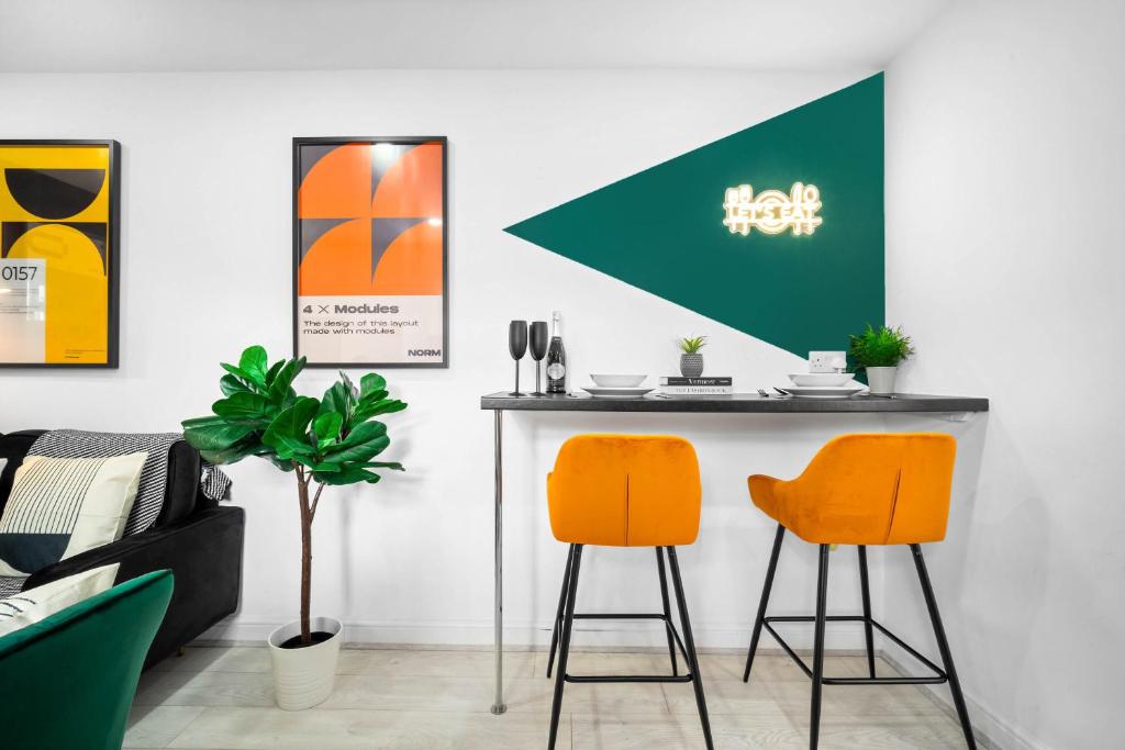 伯明翰Luxury 3 Bedroom Apartment - Terrace - WiFi - Smart TV 1MR的一间酒吧,在房间内摆放两把橙色椅子