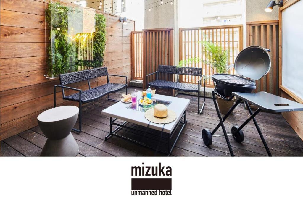 福冈mizuka Daimyo 6 - unmanned hotel -的露台配有椅子和桌子,甲板上配有桌子
