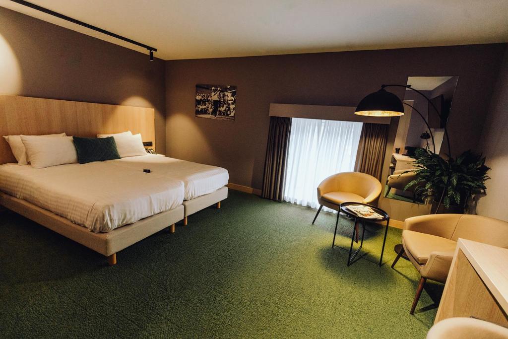 杜柏Hôtel Five Nations的酒店客房带一张床、一张桌子和椅子