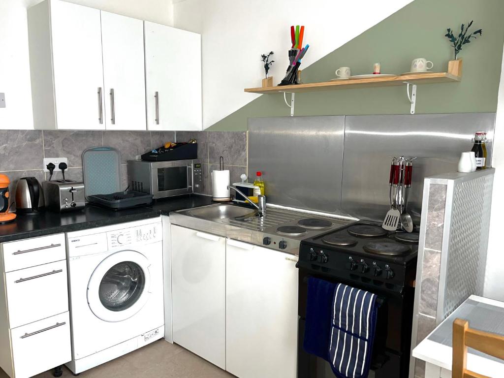 GoodmayesCrescent Apartment - Modern 1 Bedroom First Floor的厨房配有洗衣机和洗衣机。