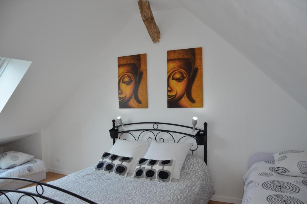 Baugé拉格兰奇德拉甘多尼里度假屋的卧室配有一张墙上有两张照片的床。