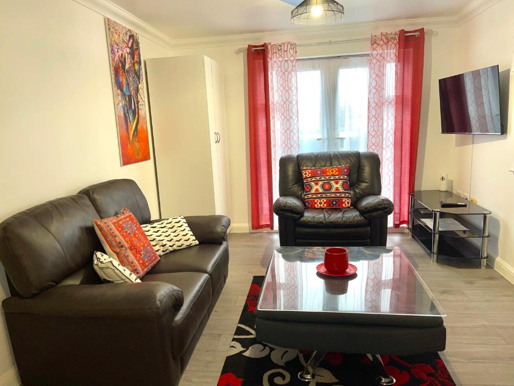 达格纳姆Forsyth Court Apartment - Two bedroom的客厅配有2把皮椅和咖啡桌