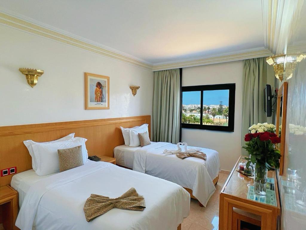 拉巴特Majliss Hotel Downtown的酒店客房设有两张床和窗户。