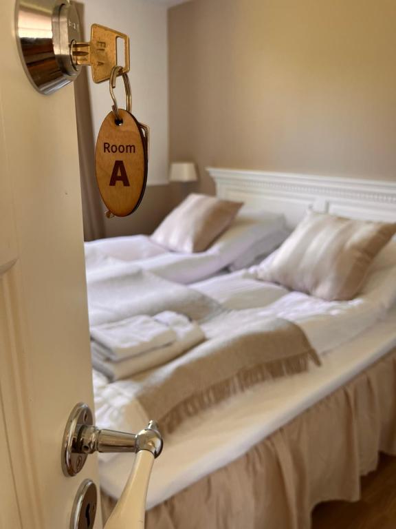 勒兹维Munkgaard Bed & Breakfast的卧室配有一张床,房间的门上有一个标志